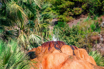 Turkey. Karahayit (near the city of Denizli) - red-brown-orange travertine with mineral water with iron oxide.