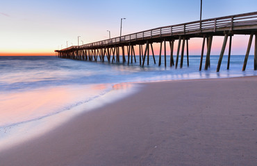 Fototapeta premium Fishing Pier at Sunrise at Virginia Beach, Virginia, USA. Virginia Beach, a coastal city in southeastern Virginia, lies where the Chesapeake Bay meets the Atlantic Ocean.