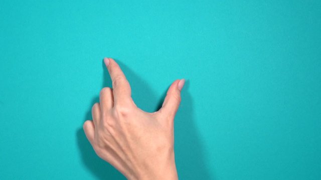 Closeup view of two manicured female fingers making gesture as if zooming pages of browser.