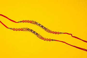 Indian traditional festival Raksha Bandhan, Elegant Rakhi on yellow background.