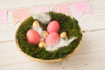 Easter. Multicolored Easter eggs lie in a basket on a white wooden background. Spring, holiday.