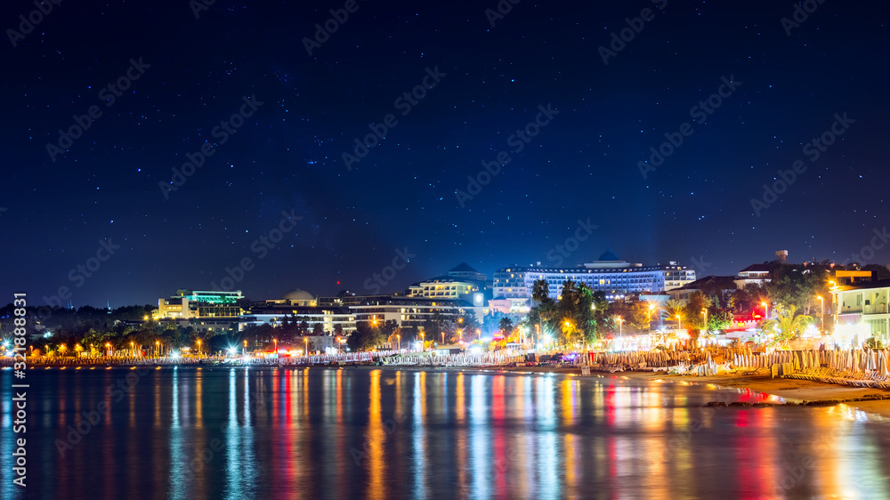 Wall mural beautiful starlight night cityscape, view of side city at night. night reflections of lights in medi