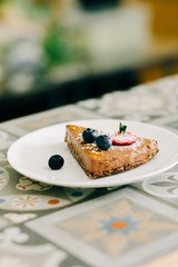 delicious slice of chocolate cake with berries on a white plate in a restaurant