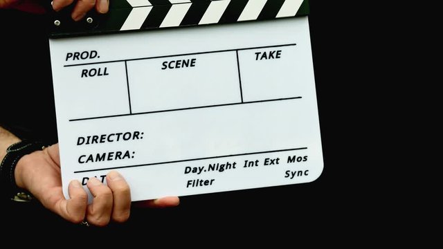 Footage of a person using a clapper board isolated on a black background