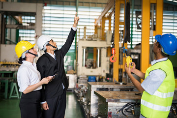 Factory manager command lifting crane in warehouse