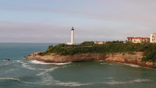 Phare de Biarritz. Drone flight pulling back from lighthouse. Atlantic Ocean, Cape Hainsart, Biarritz, France.