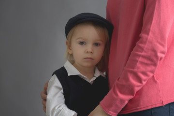 Sad little child, boy, hugging his mother at home, isolated image, copy space