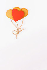 Obraz na płótnie Canvas Balloons from heart shaped cookies on a white backround. Simbol of cozy love and Valentines Day backrgound, greeting card