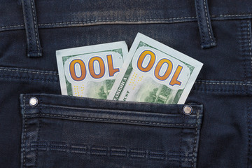 One hundred dollar banknote money in pocket jeans pants background texture. 100 dollar bill close up