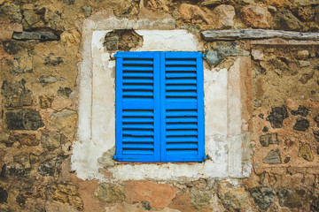 old rustic window with blue closed shutters in Mallorca, Spain