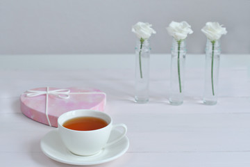 One small cup of tea with white Eustomas.Valentine card.Template greeting card for Valentine's Day. Spring card for Mother's Day, Women's Day.copy space. March 8.breakfast for loved ones