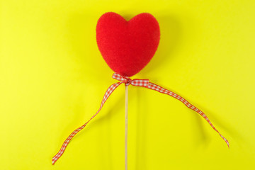 Red heart heart on a yellow background. Valentine's Day. Close-up.