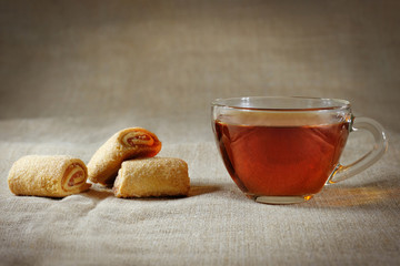 Glass cup of tea, and homemade cookies on a dark background.