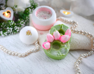 Fototapeta na wymiar Beautiful spa composition with bath bombs, flower soap, towel on light background. Mothers day, Women day or wedding lifestyle concept. 8 March greeting card