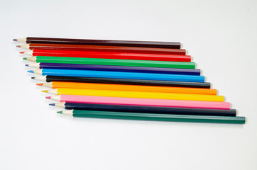 stack of pencils of different colors on a white background