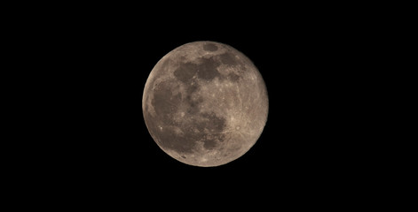 full moon in the black sky background. Photo taken with big telephoto zoom lens from Earth