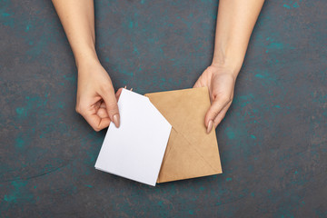 Female hands put the letter in the craft envelope