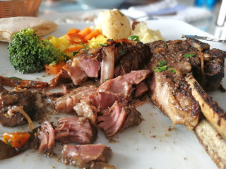 cut pieces of meat on the bone. Kleftiko dish cuisine of Cyprus. Stewed lamb meat served with vegetables, herbs and mashed potatoes