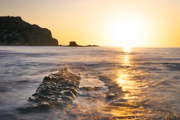 amanecer en cala con rocas