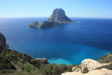 Fototapeta na wymiar The magical island of Es Vedra with the small islet of Es Vedranell next to it in front of the coast of Cala d'Hort in the tourist island of Ibiza in the midst of nature between cliffs,