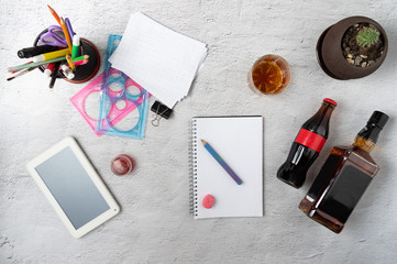 Folding up a business plan. Office work. Stationery and drinks on the office desk.