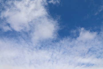 Thin cumulus clouds against a blue sky