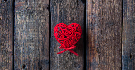 Red heart on a wooden background. Little red bow. Love