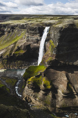 Aerial view of Haifoss big waterfall in south Iceland. Black high rocks, green hills and nobody around. Sunny summer weather.