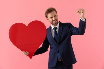 Happy businessman celebrating with a heart shape and laughing