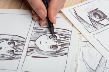 Artist drawing an anime comic book in a studio. - obrazy, fototapety, plakaty