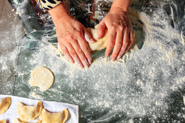 The housewife hands knead the dough for making dumplings in Ukrainian national cuisine.