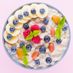 Healthy breakfast. Bowl of oatmeal porridge with fresh blueberries, raspberries, almonds and banana. Clean eating, dieting, detox, vegetarian food concept. Healthy lifestyle concept