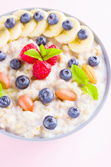 Healthy breakfast. Bowl of oatmeal porridge with fresh blueberries, raspberries, almonds and banana. Clean eating, dieting, detox, vegetarian food concept. Healthy lifestyle concept