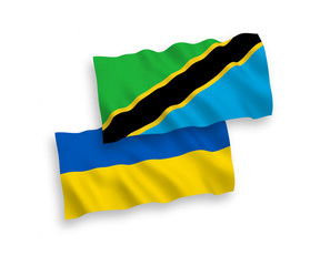 National vector fabric wave flags of Tanzania and Ukraine isolated on white background. 1 to 2 proportion.