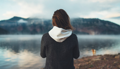 hipster tourist relax on foggy lake, mist mountain nature, traveler girl enjoy breathing of fresh...
