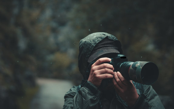 Hombre tomando una fotografía bajo la lluvia