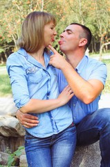 Fototapeta premium family shot in the park, summer day. .a guy with a girl dressed in a denim suit. very happy, cheerful and in love