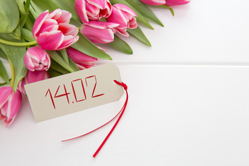 Vlentine's Day card and a bouquet of beautiful tulips on wooden background.