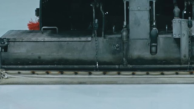 Zamboni resurfacing an indoor skating rink. Slow Motion. Ice resurfacer cleaning ice, machine cleaning and polishing smooth icerink. Ice harvester or restores ice.
