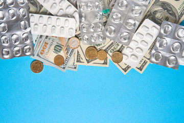 pills empty blisters for drugs individual syringe and money lie on a blue background