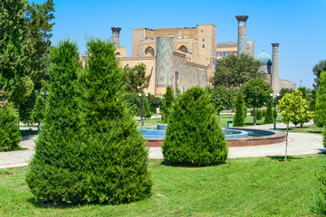 Fototapeta na wymiar View of the Registan architectural ensemble through the garden, Samarkand, Uzbekistan