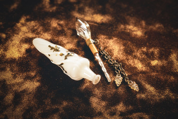 Old perfume bottle on golden velvet cloth background close up.