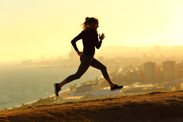 Full body of runner woman running at sunset