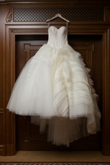 Wedding dress is hanging on the closet. Stylish photo