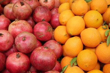  Pomegranates and oranges in the market. Colored fruit background, pattern, banner.