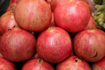 Fototapeta na wymiar Pomegranates in the market close-up. Fruit background, pattern, banner.