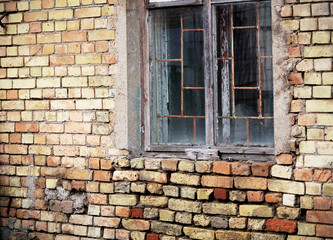Aged window with bars in brick wall