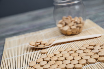 Alternative medicine tablets on a wooden spoon