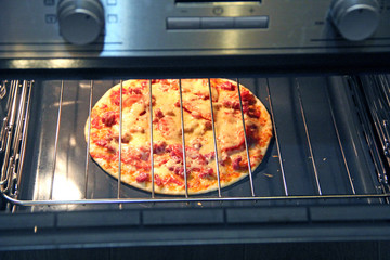 Cook preparing delicious pizza in oven. Cooking fast food in restaurant