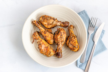 Baked Chicken Drumsticks on a White Background, Top View Photo..